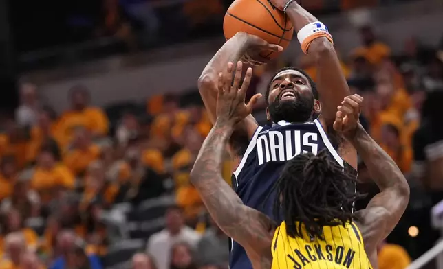 Dallas Mavericks guard Kyrie Irving, top, looks to shoot over Indiana Pacers guard Quenton Jackson, bottom, during the second half of an NBA basketball game in Indianapolis, Friday, Oct. 23, 2026. (AP Photo/AJ Mast)