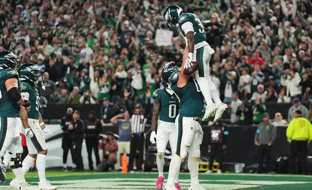 Philadelphia Eagles running back Dameon Pierce (39) is lifted by Philadelphia Eagles guard Landon Dickerson (69) after Pierce scored a touchdown during the first half of an NFL football game against the Dallas Cowboys in Philadelphia, Monday, Oct. 26, 2026. (AP Photo/Matt Rourke)