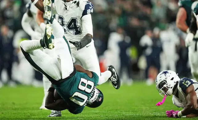 Philadelphia Eagles wide receiver Darius Cooper (80) is upended by Dallas Cowboys safety Caleb Downs (13) during the first half of an NFL football game in Philadelphia, Monday, Oct. 26, 2026. (AP Photo/Matt Rourke)