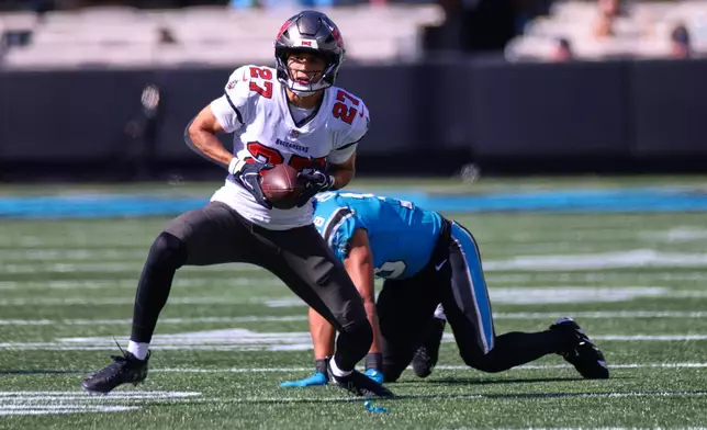Tampa Bay Buccaneers' Zyon McCollum (27) intercepts a pass to Carolina Panthers' Jalen Coker (18) during the first half of an NFL football game in Charlotte, N.C., Sunday, Oct. 25, 2026. (AP Photo/Scott Kinser)