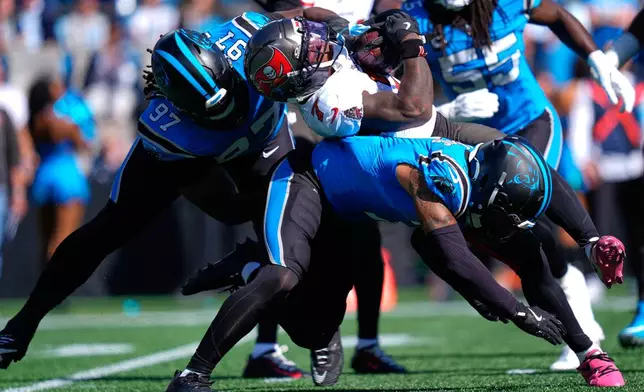 Carolina Panthers' Bobby Brown III (97) tackles Tampa Bay Buccaneers' Bucky Irving (7) during the first half of an NFL football game in Charlotte, N.C., Sunday, Oct. 25, 2026. (AP Photo/Erik Verduzco)
