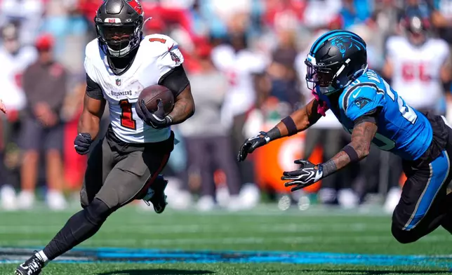 Tampa Bay Buccaneers' Kenny Gainwell (1) runs past Carolina Panthers' Zakee Wheatley (20) during the first half of an NFL football game in Charlotte, N.C., Sunday, Oct. 25, 2026. (AP Photo/Erik Verduzco)