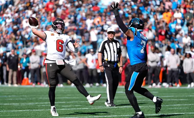 Tampa Bay Buccaneers quarterback Baker Mayfield (6) throws a touchdown pass over Carolina Panthers' Tre'von Moehrig (7) during the first half of an NFL football game in Charlotte, N.C., Sunday, Oct. 25, 2026. (AP Photo/Erik Verduzco)