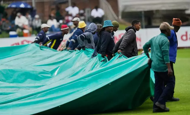 Groundsmen pull the covers as rain delays match on day one of the second cricket test match between South Africa and Australia, in Gqeberha, South Africa, Sunday, Oct. 18, 2026. (AP Photo/ Themba Hadebe)