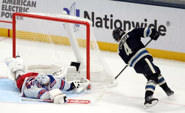 New York Rangers goalie Dylan Garand, left, stops a shot by Columbus Blue Jackets forward Cole Sillinger during the third period of a NHL hockey game in Columbus, Ohio, Saturday, Oct. 17, 2026. (AP Photo/Paul Vernon)