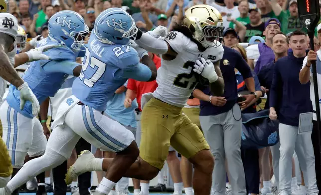 Notre Dame linebacker Kyngstonn Viliamu-Asa, right, runs back an interception against North Carolina running back Jaylen McGill, left, during the first half of an NCAA college football game Saturday, Oct. 3, 2026, in Chapel Hill, N.C. (AP Photo/Chris Seward)