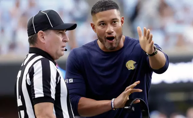 Notre Dame head coach Marcus Freeman discusses a call with an official during the first half of an NCAA college football game against North Carolina, Saturday, Oct. 3, 2026, in Chapel Hill, N.C. (AP Photo/Chris Seward)