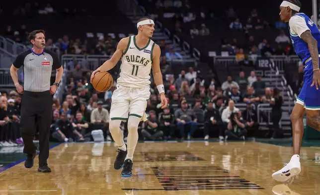 Milwaukee Bucks' guard Tyler Herro, left, brings the ball up the court against Minnesota Timberwolves forward Jaden McDaniels', right, during a preseason NBA basketball game Monday, Oct. 5, 2026, in Milwaukee. (AP Photo/Kylie Bridenhagen)
