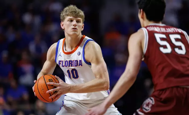 FILE - Florida forward Thomas Haugh (10) looks to pass as South Carolina guard Mike Sharavjamts (55) defends during the second half of an NCAA college basketball game, Feb. 17, 2026, in Gainesville, Fla. (AP Photo/Chris Watkins, File)