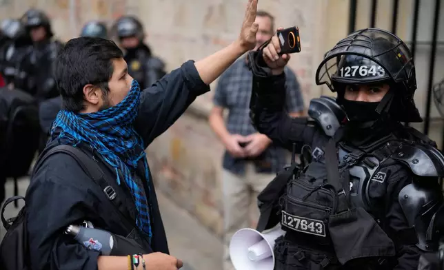 A demonstrator confronts a police officer during a protest against President Abelardo de la Espriella's order to remove exhibits about political violence from the National Museum in Bogota, Colombia, Saturday, Oct. 17, 2026. (AP Photo/Fernando Vergara)