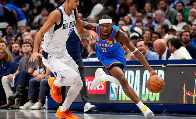 Oklahoma City Thunder guard Shai Gilgeous-Alexander (2) drives past Dallas Mavericks forward Zaccharie Risacher during the first half of an NBA basketball game Wednesday, Oct. 28, 2026, in Dallas. (AP Photo/Jeffrey McWhorter)