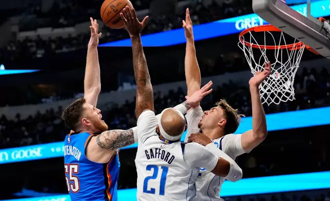 Oklahoma City Thunder center Isaiah Hartenstein (55) shoots over Dallas Mavericks forward Daniel Gafford (21) and forward Cooper Flagg during the first half of an NBA basketball game Wednesday, Oct. 28, 2026, in Dallas. (AP Photo/Jeffrey McWhorter)