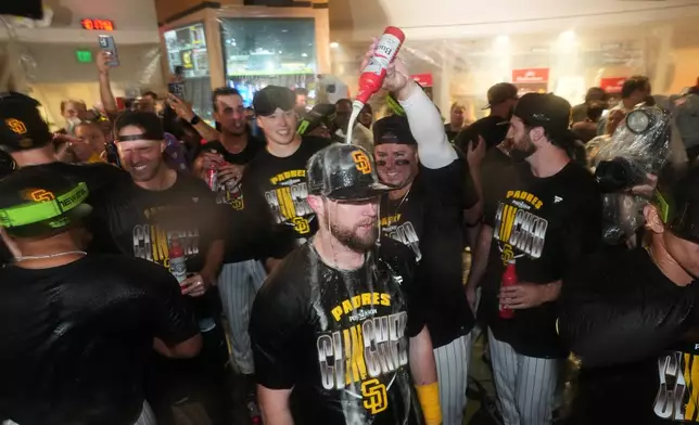 San Diego Padres first baseman Ty France pours beer on second baseman Jake Cronenworth as they celebrate defeating the Chicago Cubs in Game 2 of the National League Wild Card baseball playoff series Wednesday, Sept. 30, 2026, in San Diego. (AP Photo/Gregory Bull)