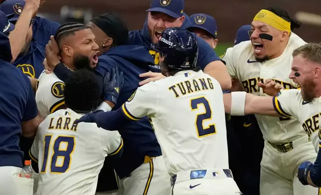 Milwaukee Brewers' Jackson Chourio is congratulated after hitting a walkoff hit during the ninth inning of Game 2 of a National League Divisional baseball playoff series against the San Diego Padres Sunday, Oct. 4, 2026, in Milwaukee. (AP Photo/Chris Carlson)