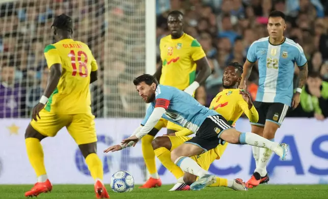 Argentina's Lionel Messi, center, and Benin's Imourane Hassane battle for the ball during Messi's final match for the national team, a soccer friendly against Benin, in Buenos Aires, Argentina, Tuesday, Oct.6, 2026. (AP Photo/Gustavo Garello)