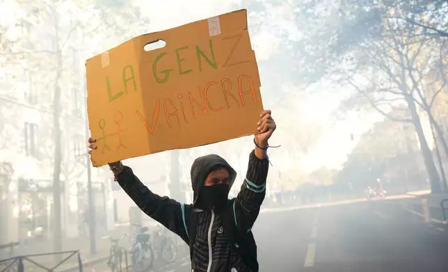 A student holds a board reading 'GenZ will win' during a protest against under-resourced schools, in Paris, Tuesday, Oct. 6, 2026. (AP Photo/Teresa Suarez)