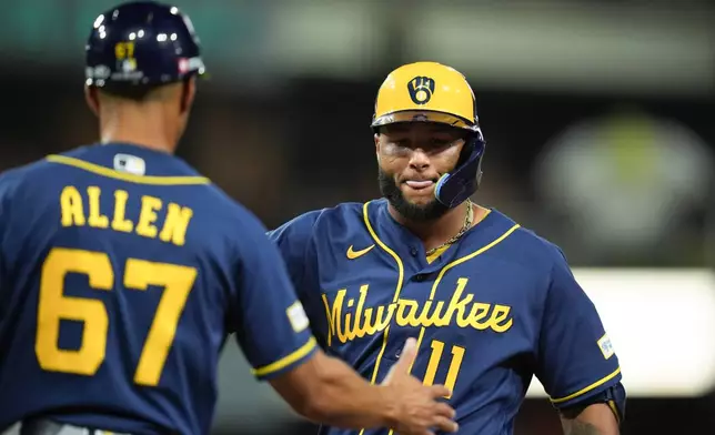 Milwaukee Brewers' Jackson Chourio (11) is congratulated by first base coach Spencer Allen (67) after hitting an RBI single against the San Diego Padres during the fifth inning in Game 4 of baseball's National League Division Series Wednesday, Oct. 7, 2026, in San Diego. (AP Photo/Gregory Bull)