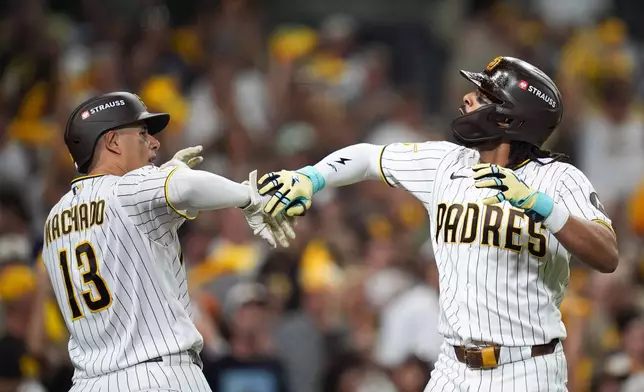 San Diego Padres' Fernando Tatis Jr., right, celebrates his home run with Manny Machado during the third inning in Game 4 of baseball's National League Division Series against the Milwaukee Brewers Wednesday, Oct. 7, 2026, in San Diego. (AP Photo/Gregory Bull)