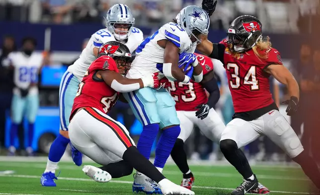 Tampa Bay Buccaneers linebacker Josiah Trotter (45) stops Dallas Cowboys running back Javonte Williams (33) in the first half of an NFL football game in Arlington, Texas on Thursday, Oct. 8, 2026. (AP Photo/Julio Cortez)