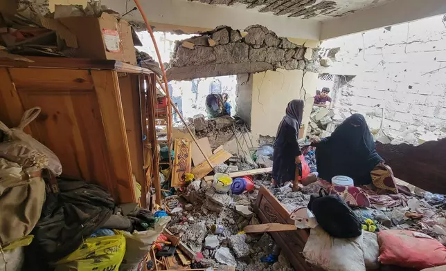 Residents walk on their home debris at Seina district in Taiz, Yemen, after a missile strike, Tuesday, Oct. 20, 2026. (AP Photo/Marzouq Al Jabri)