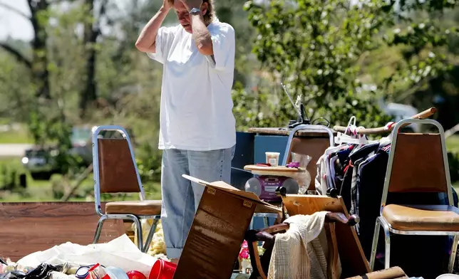 FILE - Edie Kearns stands on the floor of her home that was destroyed by a tornado associated with Hurricane Ivan in Marianna, Fla., Sept. 17, 2004. (AP Photo/Eric Gay, File)