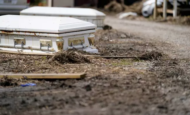 FILE - Caskets, that floated from their tombs during flooding from Hurricane Ida, sit along a roadside in Ironton, La., Sept. 27, 2021. (AP Photo/Gerald Herbert, File)