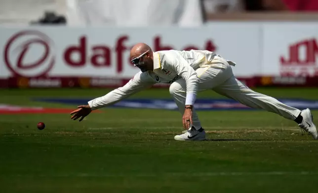 Australia's Nathan Lyon stretches as he attempts fielding his own bowling on day three of the first cricket test match between South Africa and Australia, in Durban, South Africa, Sunday, Oct. 11, 2026. (AP Photo/Themba Hadebe)