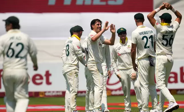 Australia's captain Pat Cummins, center, celebrates with his teammates after taking a wicket of South Africa's David Bedingham on day three of the first cricket test match between South Africa and Australia, in Durban, South Africa, Sunday, Oct. 11, 2026. (AP Photo/Themba Hadebe)