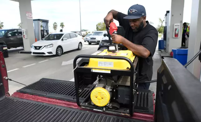 Residents fill up their gas tanks and generators at the Costco Wholesale Gas Station ahead of Hurricane Isaias' expected landfall along the Gulf Coast, Thursday, Oct. 8, 2026, in Mobile, Ala. (AP Photo/Octavio Jones)