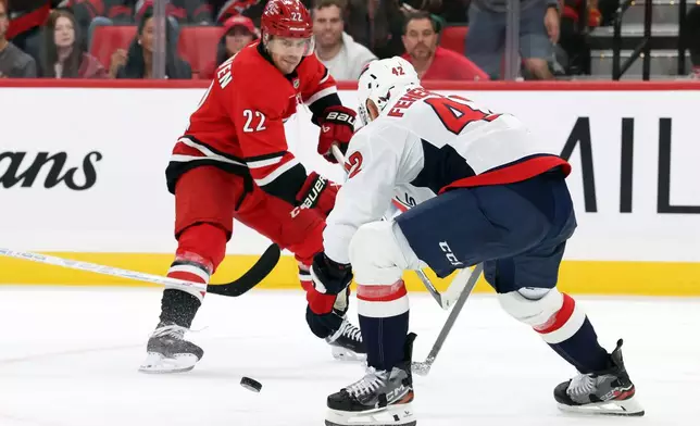 Carolina Hurricanes' Logan Stankoven (22) tries to pass the puck past Washington Capitals' Martin Fehérváry (42) during the second period of an NHL hockey game in Raleigh, N.C., Friday, Oct. 2, 2026. (AP Photo/Karl DeBlaker)