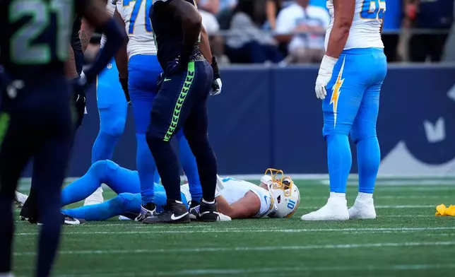 Los Angeles Chargers quarterback Justin Herbert (10) lies on the ground after getting tackled during the second half of an NFL football game against the Seattle Seahawks, Sunday, Oct. 4, 2026, in Seattle. (AP Photo/Lindsey Wasson)