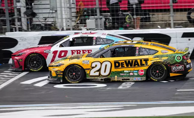 Chase Briscoe (19) beats Christopher Bell (20) to the finish line to win a NASCAR Cup Series auto race, Sunday, Oct. 11, 2026, in Concord, N.C. (AP Photo/Matt Kelley)