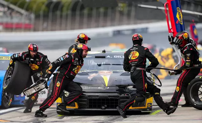 The pit crew for Austin Dillon rushes to complete a pit stop during a NASCAR Cup Series auto race, Sunday, Oct. 11, 2026, in Concord, N.C. (AP Photo/Matt Kelley)