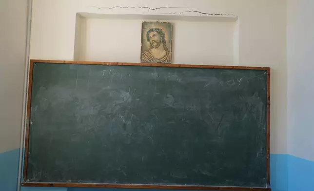 A picture depicting Jesus Christ is displayed above a chalkboard in an unused classroom at Kalamos Primary School, which has only two students, both in sixth grade, on the island of Kalamos in the Ionian Sea, western Greece, Wednesday, Sept. 23, 2026. (AP Photo/Petros Giannakouris)