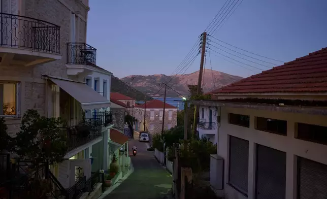 A man rides a motorcycle along an empty street on the island of Kalamos in the Ionian Sea, western Greece, Wednesday, Sept. 23, 2026. (AP Photo/Petros Giannakouris)