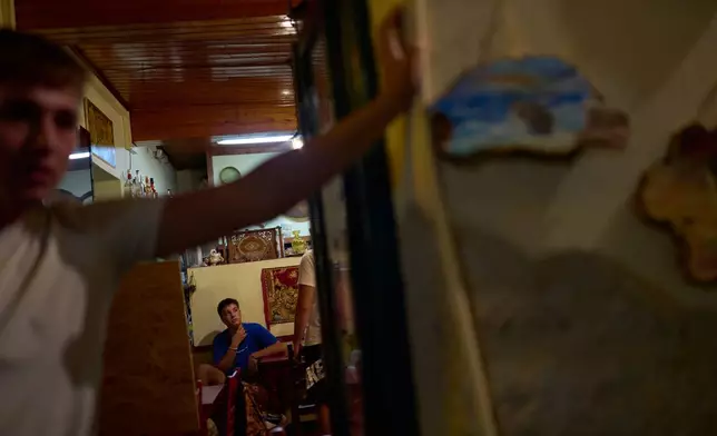 High school student John Kestegias stands on a chair while meeting friends at a snack bar on the island of Kalamos in the Ionian Sea, western Greece, Wednesday, Sept. 23, 2026. (AP Photo/Petros Giannakouris)