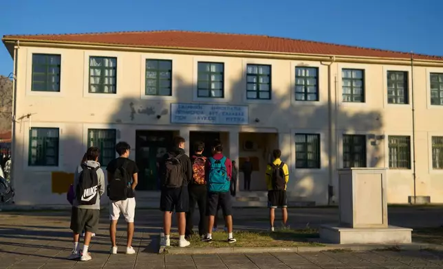 High school students wait for classes to begin at a school in the mainland town of Mytikas, western Greece, early Thursday, Sept. 24, 2026. (AP Photo/Petros Giannakouris)
