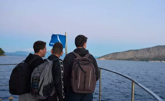 Middle and high school students travel by passenger boat across the Ionian Sea from the island of Kalamos, where they live, to schools in the mainland town of Mytikas, western Greece, early Thursday, Sept. 24, 2026. (AP Photo/Petros Giannakouris)