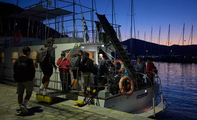 Middle and high school students board a passenger boat on the island of Kalamos to travel to schools in the mainland town of Mytikas, western Greece, early Thursday, Sept. 24, 2026. (AP Photo/Petros Giannakouris)