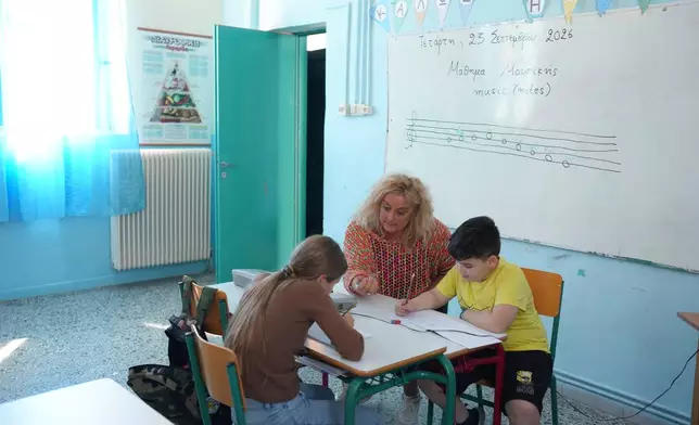 Teacher Chryssa Ntalaka teaches music to the two students of Kalamos Primary School, including Gerasimos Mitsopoulos, 11, right, on the island of Kalamos in the Ionian Sea, western Greece, Wednesday, Sept. 23, 2026. (AP Photo/Petros Giannakouris)