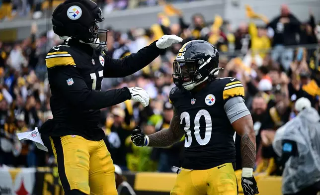 Pittsburgh Steelers running back Jaylen Warren (30) celebrates a touchdown with wide receiver Germie Bernard (17) against the Indianapolis Colts during the second half of an NFL football game in Pittsburgh, Sunday, Oct. 11, 2026. (AP Photo/David Dermer )