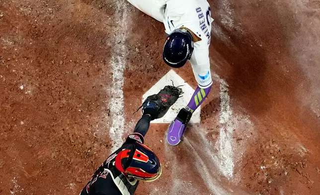 Tampa Bay Rays' Junior Caminero scores past Cleveland Guardians catcher Patrick Bailey sacrifice fly during the third inning in Game 6 of an American League Championship Series baseball game in St. Petersburg, Fla. Monday, Oct. 19, 2026. (AP Photo/David J. Phillip)