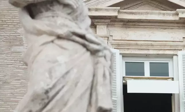 Pope Leo XIV appears at the window of his study in the Apostolic Palace overlooking St. Peter's Square at the Vatican for the traditional noon blessing after praying the Angelus, Sunday, Oct. 18, 2026, a day after he returned from the hospital, where he had lung cancer removed on Tuesday. (AP Photo/Gregorio Borgia)