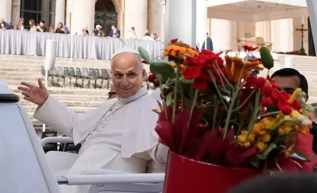 Pope Leo XIV is presented with flowers as he leaves at the end of the general audience in St. Peter's Square at The Vatican, Wednesday, Oct. 21, 2026. (AP Photo/Gregorio Borgia)