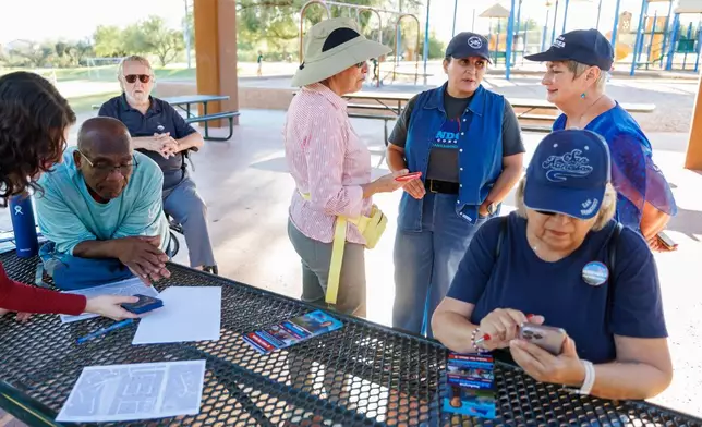 JoAnna Mendoza (D), standing second from right, an Arizona Congressional District 6 candidate, talks with campaign volunteers before a weekly neighborhood canvass, Thursday, Oct. 15, 2026, in Oro Valley, Ariz. (AP Photo/Mike Christy)