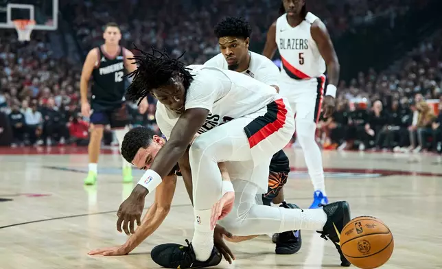 Portland Trail Blazers guard Sidy Cissoko, front, and Phoenix Suns guard Devin Booker reach for a loose ball during the first half of an NBA basketball game in Portland, Ore., Wednesday, Oct. 21, 2026. (AP Photo/Craig Mitchelldyer)