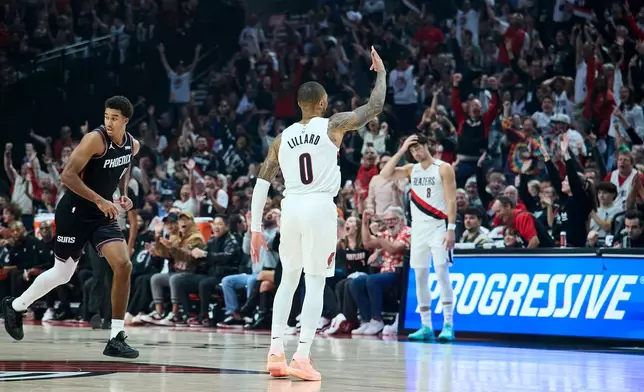 Portland Trail Blazers guard Damian Lillard (0) reacts after making a three-point basket next to Phoenix Suns forward Oso Ighodaro during the first half of an NBA basketball game in Portland, Ore., Wednesday, Oct. 21, 2026. (AP Photo/Craig Mitchelldyer)