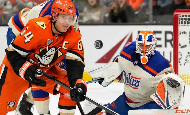 Anaheim Ducks center Mikael Granlund, left, and Edmonton Oilers goaltender Devon Levi, right, watch as the puck deflects away during the second period of an NHL hockey game Wednesday, Oct. 7, 2026, in Anaheim, Calif. (AP Photo/Mark J. Terrill)