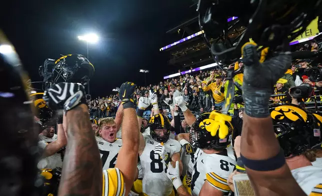 Iowa players celebrate a win over Washington after an NCAA college football game, Friday, Oct. 9, 2026, in Seattle. (AP Photo/Lindsey Wasson)