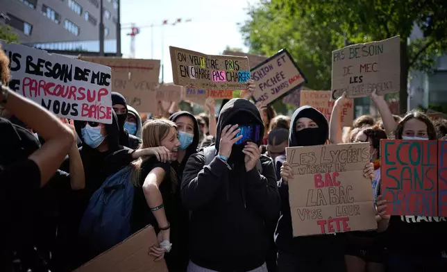 A student hold a board reading "We want to be supported, not overburdened" during protest against under-resourced schools in front of a high school blockade, in Lyon, France, Friday, Oct. 2, 2026. (AP Photo/Laurent Cipriani)